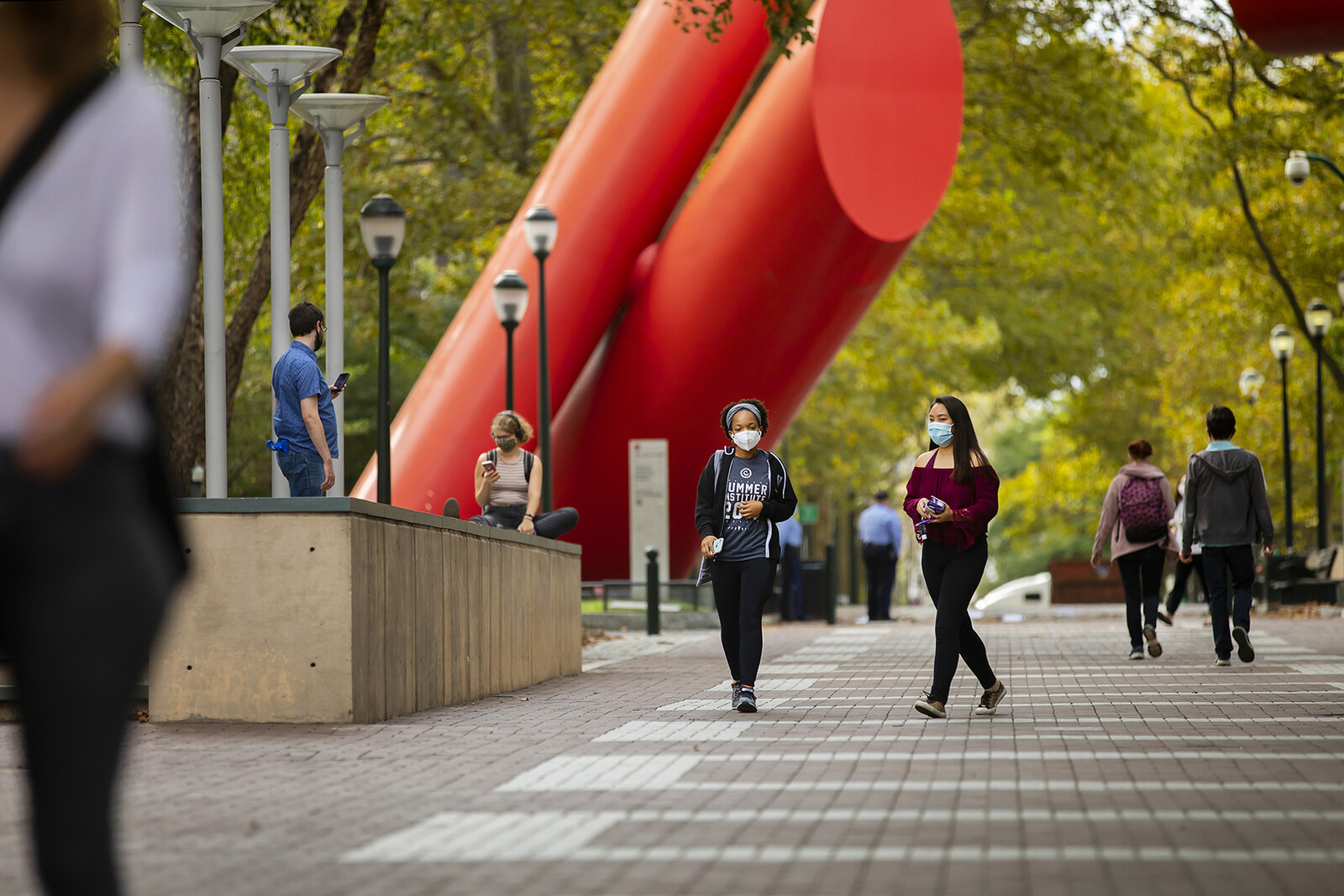 students with masks walking on locust near covenant