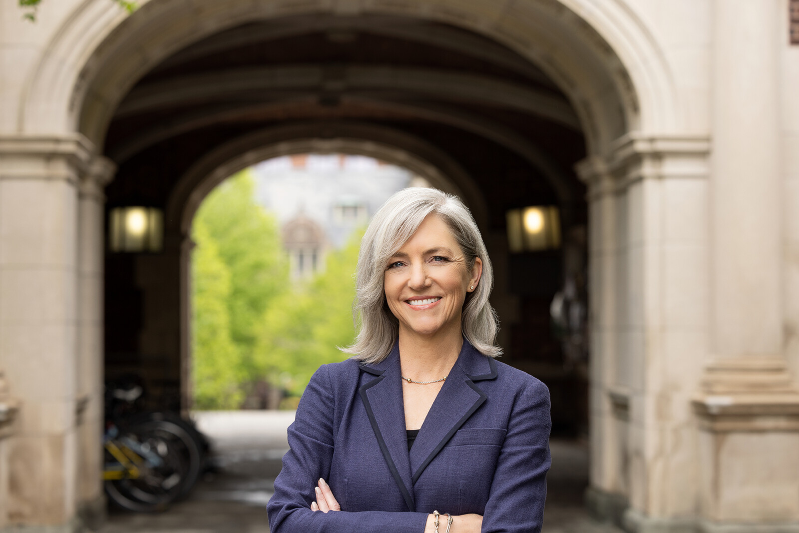 Admissions Director Whitney Soule stands beneath arched entryway at Penn's historic quadrangle.