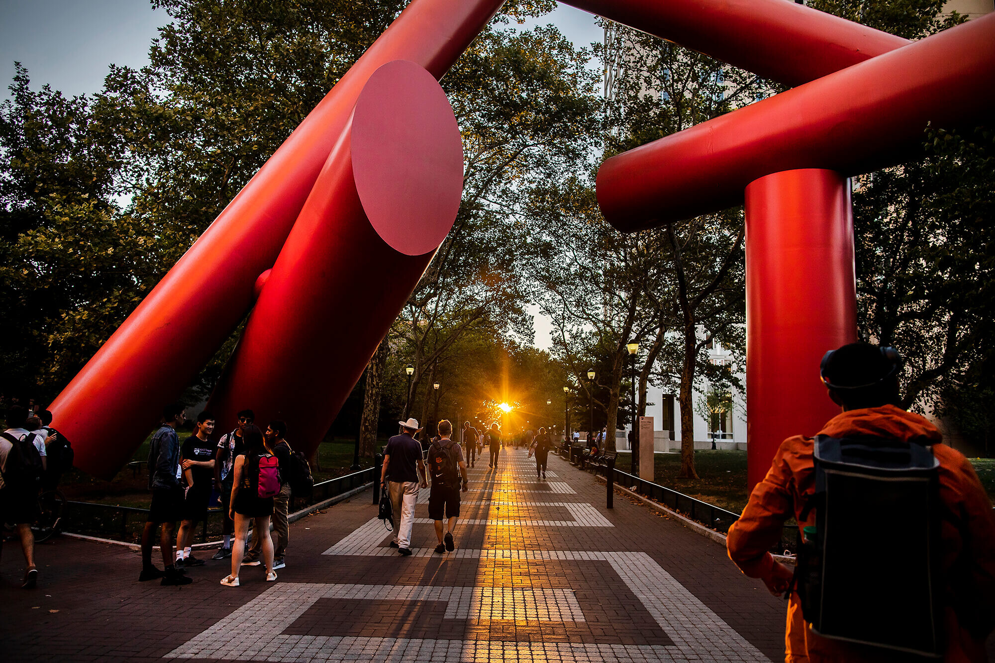 Students passing beneath the massive 'Covenant' sculpture on Locust Walk